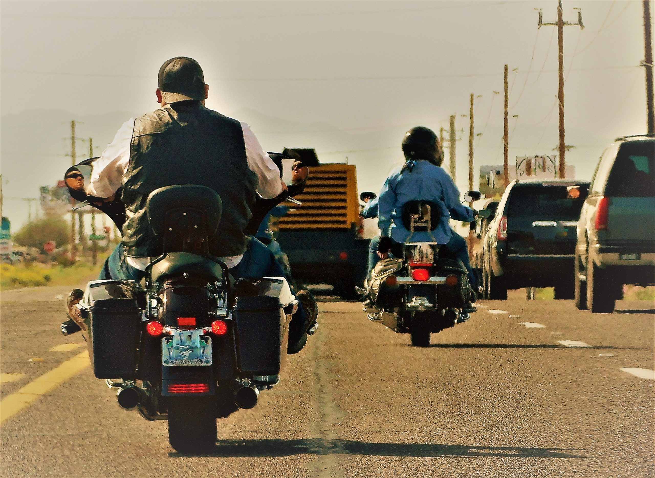 Motorcycle rider cruising on a scenic road with lush surroundings, highlighting the experience of riding on the open road.