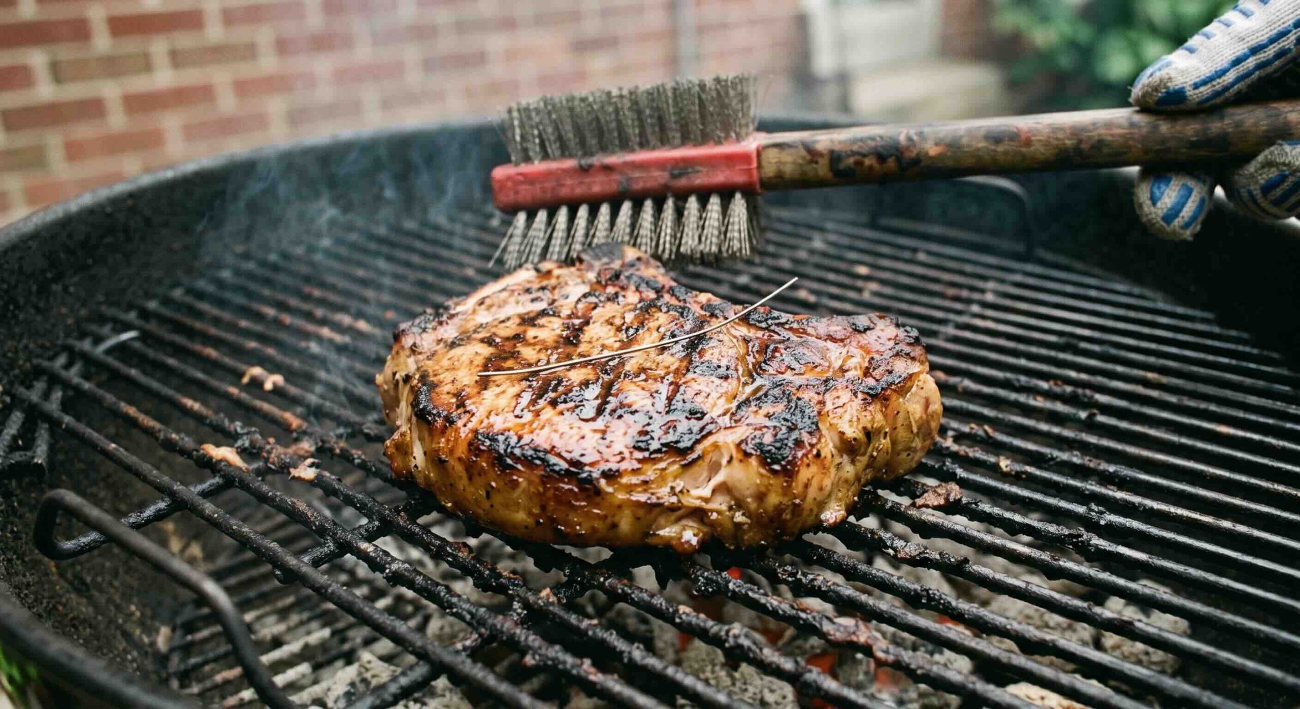 food on grill with a loose grill brush bristle resting on top